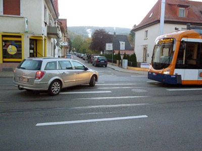 Ein Auto biegt von der Karlsruher Straße in die Parkstraße ab und blockiert die Straßenbahn