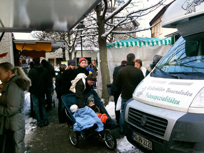 Menschen stehen Schlange auf dem Wochenmarkt